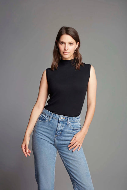 Fashionable model wearing a luxury sleeveless mock neck top paired with tailored trousers, exemplifying effortless style for both casual and formal settings.