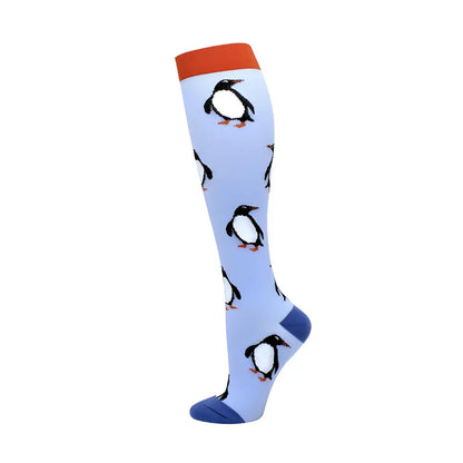 Stylish Women's Knee Length Compression Travel Socks designed with adorable penguin illustrations on a light blue fabric, merging functionality and elegance for travel.
