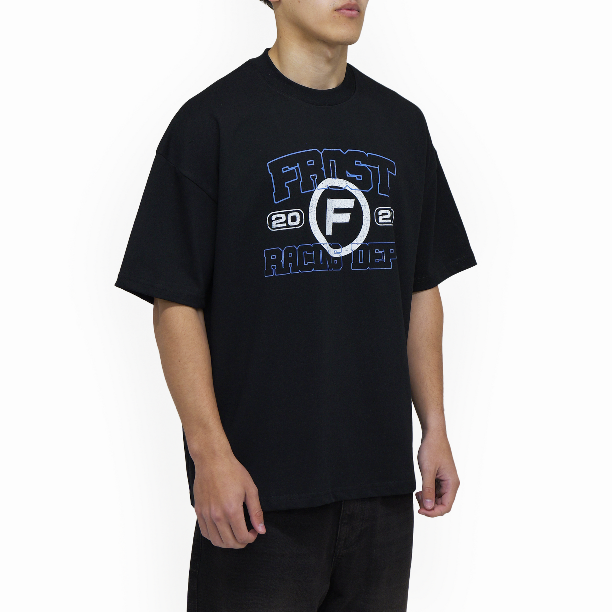 Model wearing FROST Racing Department oversized fit black t-shirt, featuring dropped shoulders and a stylish boxy cut perfect for streetwear fashion.