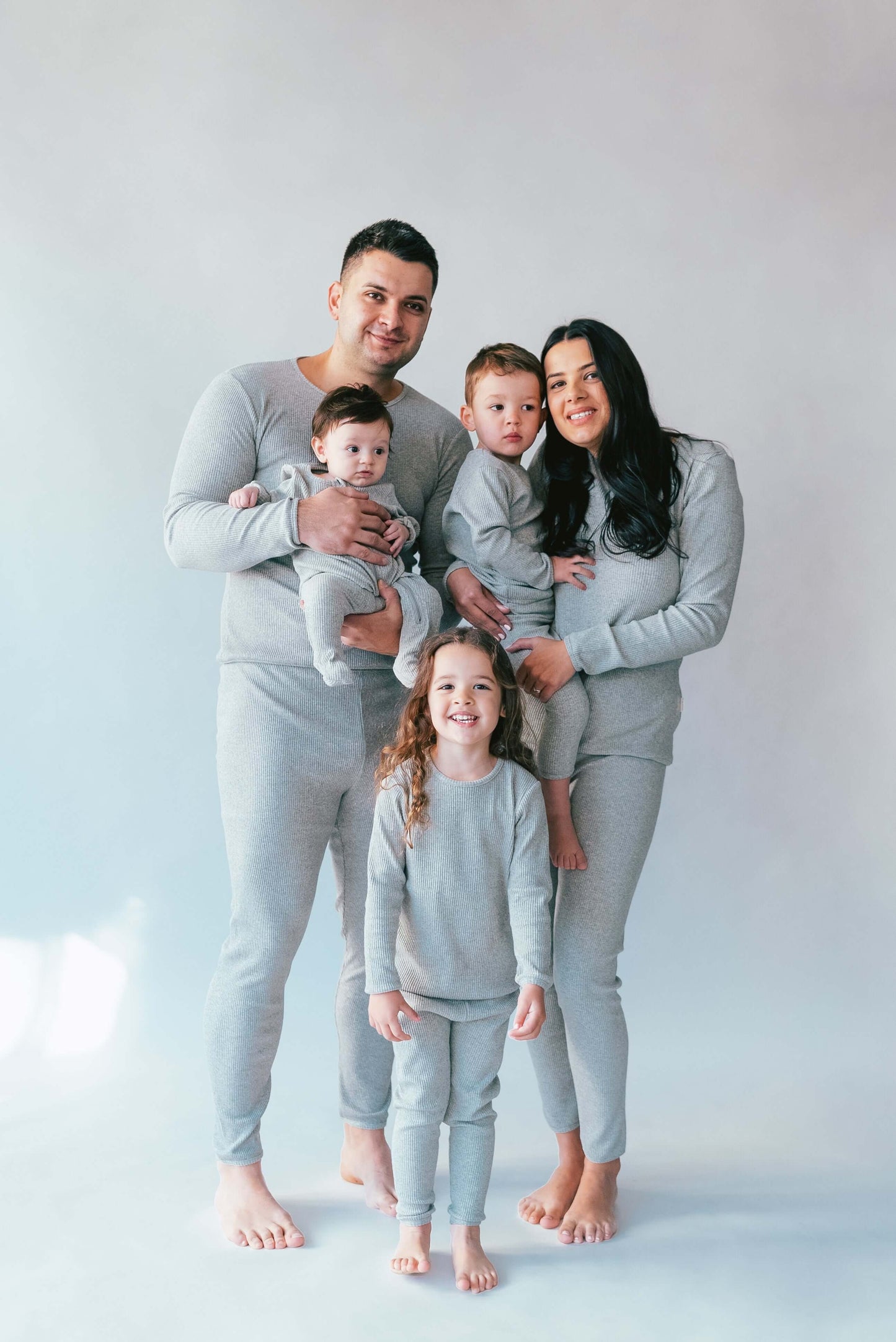 Family in DreamBuy Dove Grey Matching Pyjamas, portraying stylish coordination for holiday celebrations, perfect for relaxed lounge wear.