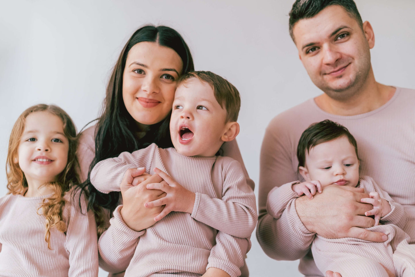 Cozy family members enjoying their matching Velvet Mocha pyjamas from DreamBuy, perfect for family gatherings and holiday celebrations.