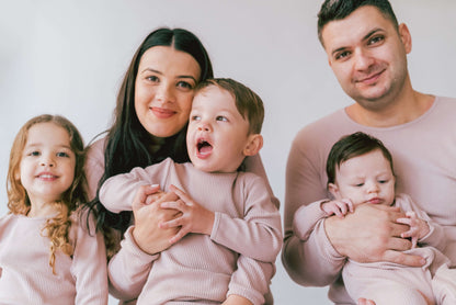 Cozy family members enjoying their matching Velvet Mocha pyjamas from DreamBuy, perfect for family gatherings and holiday celebrations.