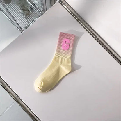 Luxurious Women's Tie-Dye Middle Tube Socks in a soft yellow with a pink ribbed top, perfect for vibrant comfort and all-day style.