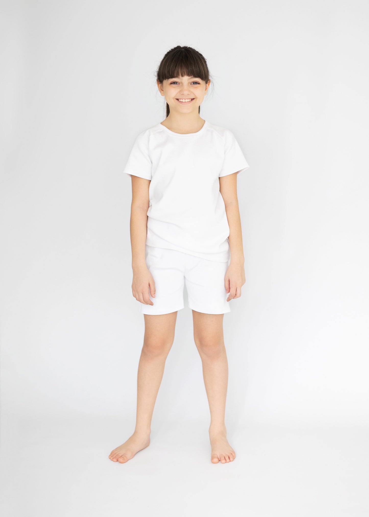 Stylishly designed DreamBuy kids summer outfit, featuring white ribbed cotton shorts and matching short sleeve top, ideal for playtime and casual outings.