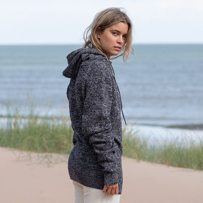 Close-up of the vibrant textured fabric of the Iguazu Recycled Knitted Hoodie, made from 70% regenerated cotton.