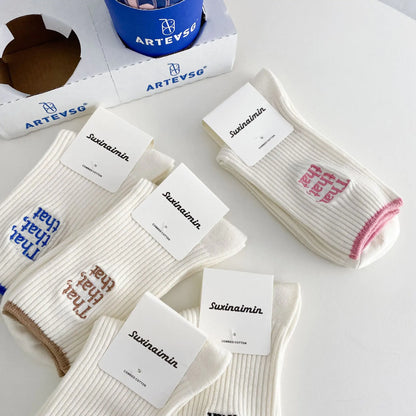 Close-up view of Elegant White Embroidered Socks for Women featuring Unique Japanese-Style Font Design on a stylish surface.