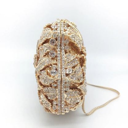 Elegant luxury women's minaudière clutch purse with sparkling crystal detailing and metallic leather design, perfect for evening events.