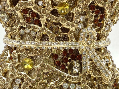 Stunning minaudiere handbag showcasing a metallic finish and sophisticated floral cut-out pattern, ideal for glamorous evening events.