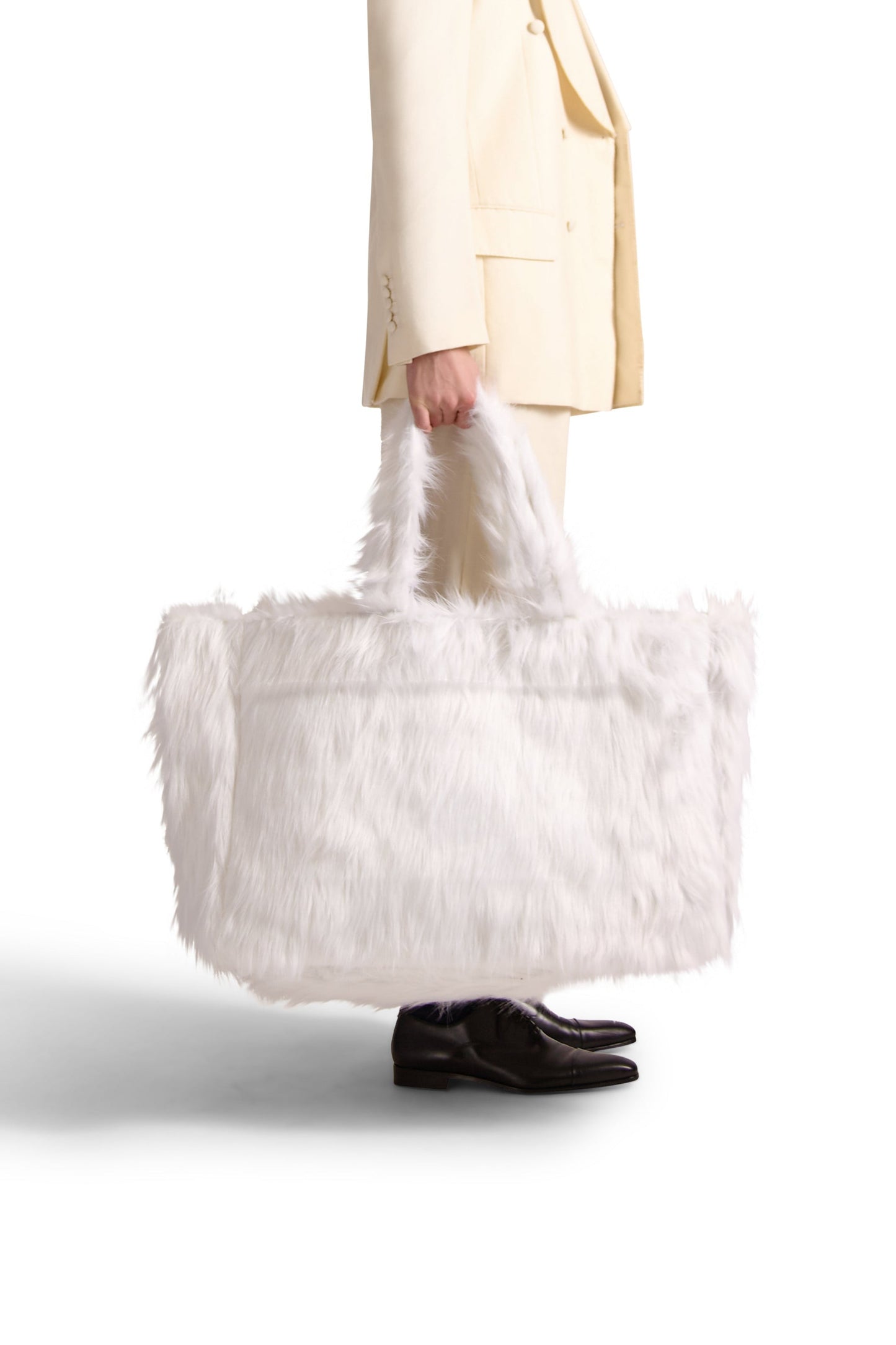 Sophisticated and spacious faux fur shoulder bag showcasing a stylish oversized silhouette, featuring a button close pouch and internal zip compartments.