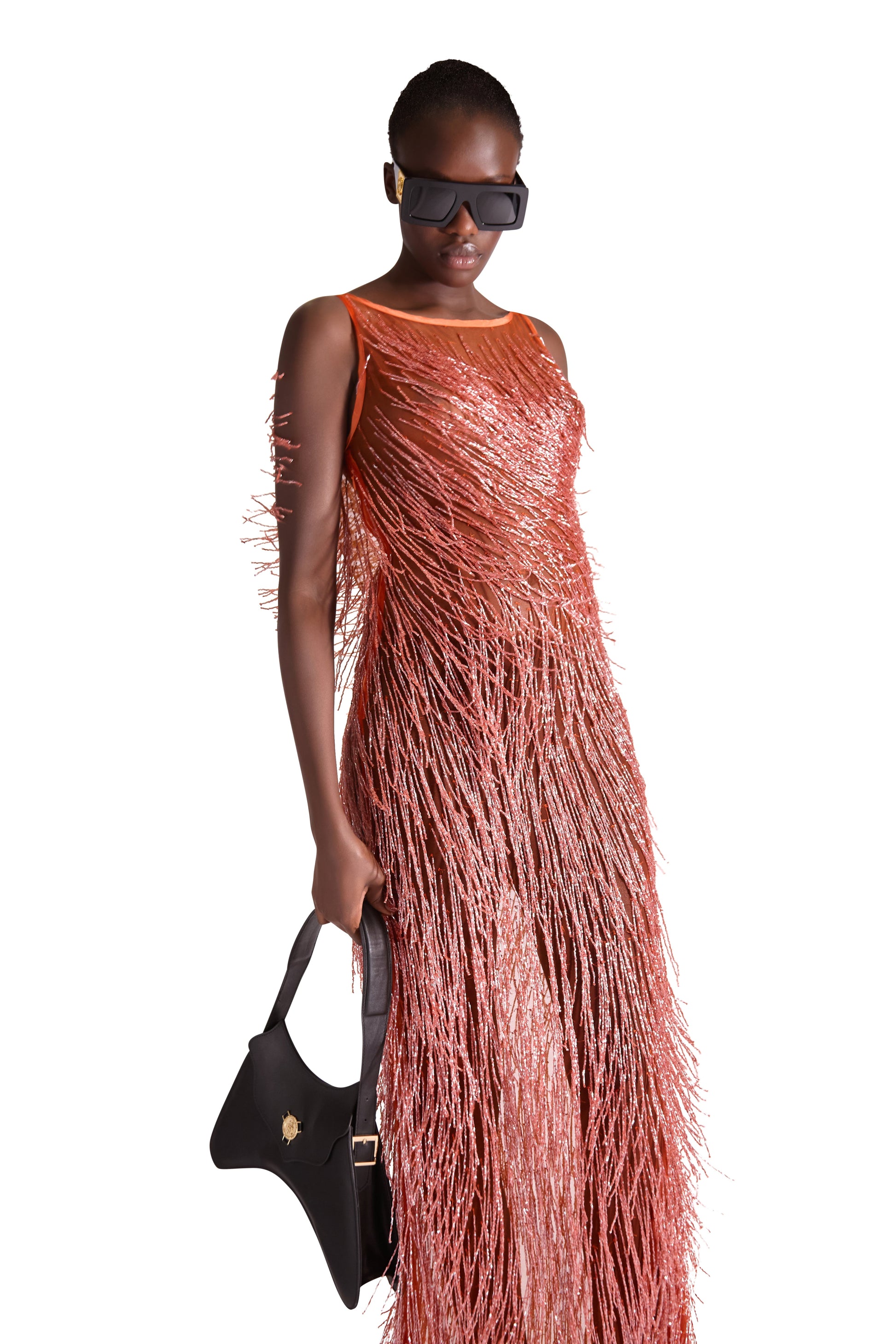 Side view of the exquisite sheer evening dress with intricate beaded embellishments, highlighting its sophisticated floor length silhouette.