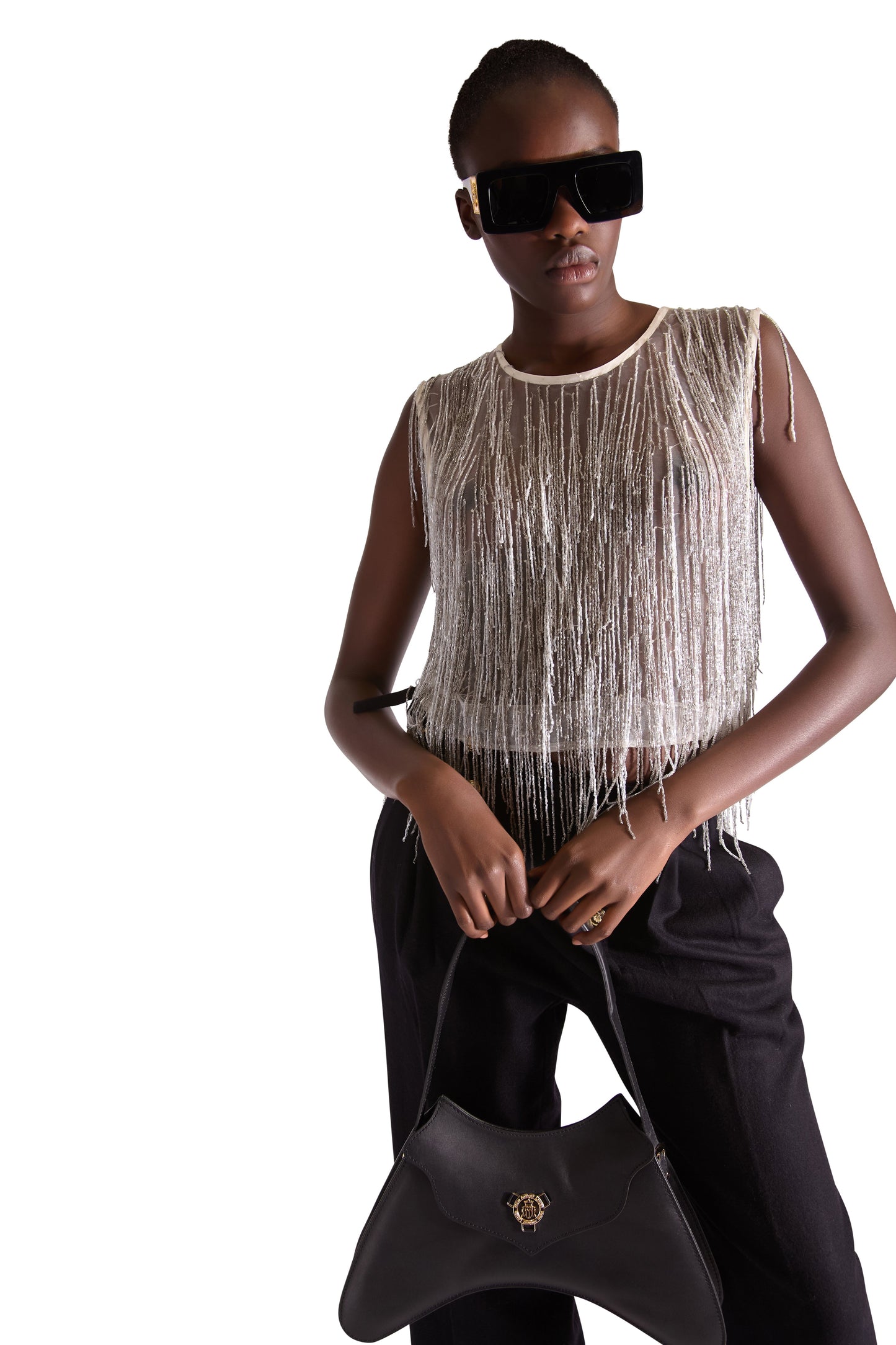 Full view of a model wearing a hand embroidered beaded tassel sleeveless crop top in sheer mesh, illustrating the stylish cropped length and sophisticated silhouette.