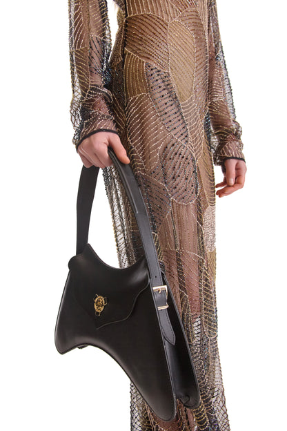 Elegant close-up view of hand embroidered beads on a sheer evening dress, showcasing its exquisite design and fine Italian craftsmanship.