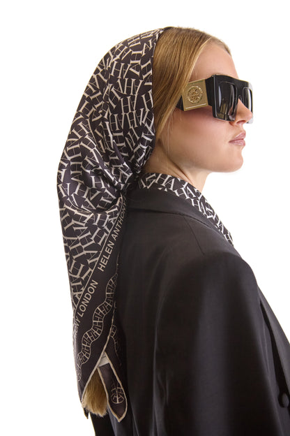 Flat lay of Helen Anthony monogram silk scarf, 90 x 90 cm, made in Italy, highlighting the soft texture and luxurious feel of 100% silk in an elegant design.