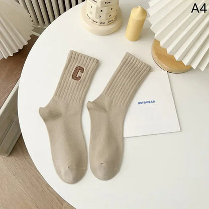 Luxurious Women's Tie-Dye Middle Tube Socks displayed in a minimalist setting, featuring a soft beige colour with a ribbed design, perfect for vibrant comfort and all-day style.