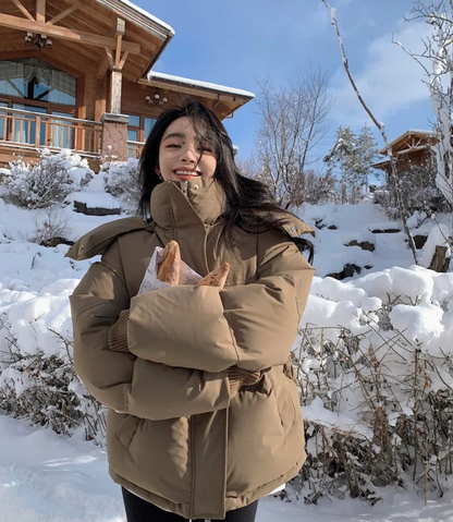 Luxury women's thick warm hooded down cotton jacket in a stylish outdoor setting, showcasing sophisticated winter fashion and practicality.