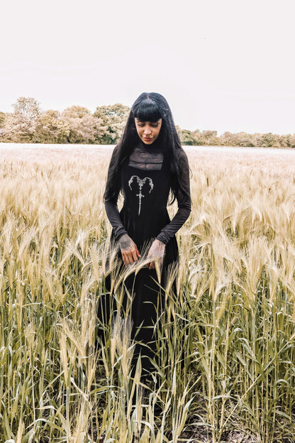 Close-up of Dark In Love Lux Black Velvet Maxi Dress displaying luxurious velvet fabric and detailed horn embroidery, ideal for a sophisticated look.