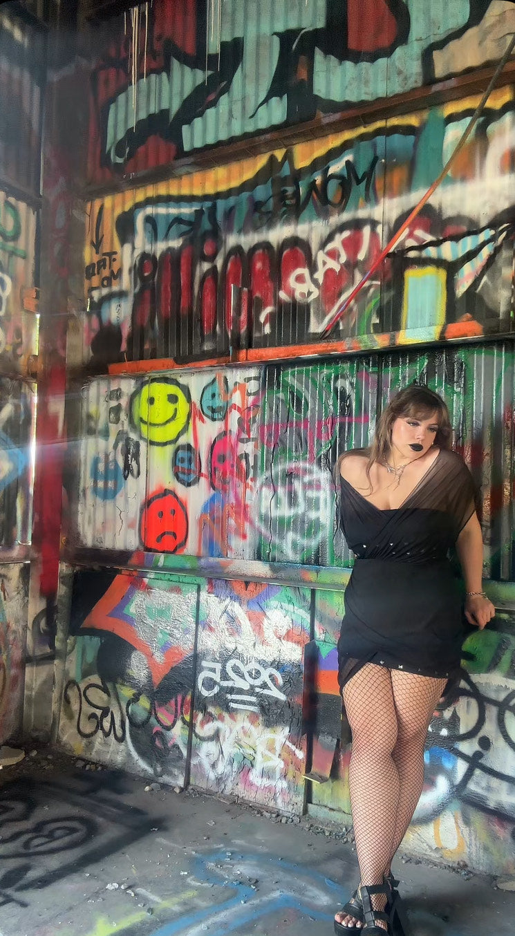 Close-up view of the dark gothic Venus Mini Dress, emphasizing the luxurious mesh fabric and bold studded accents, perfect for alternative fashion enthusiasts.