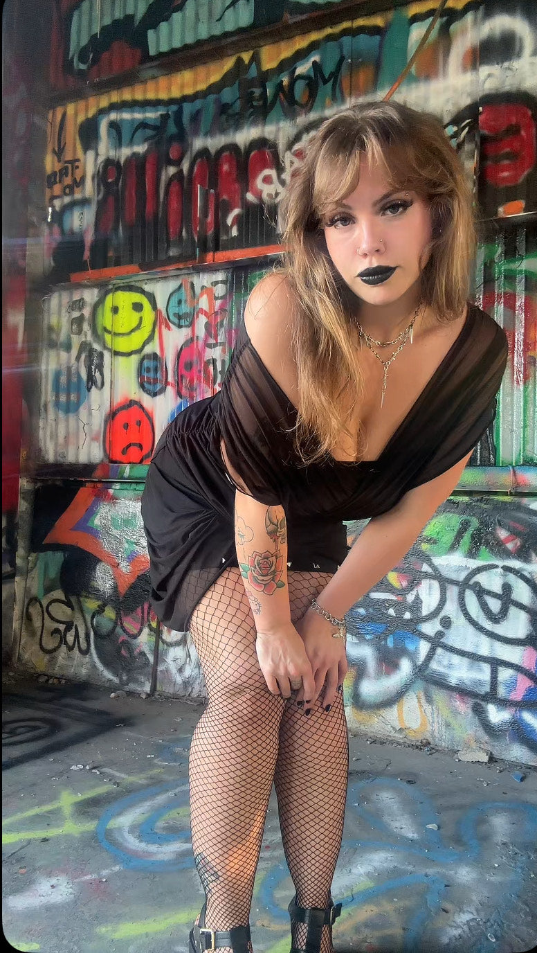 Necessary Evil Venus Wrapped Mesh Mini Dress showcasing intricate studded details on a mannequin, highlighting the edgy gothic fashion aesthetic with a sleek silhouette.