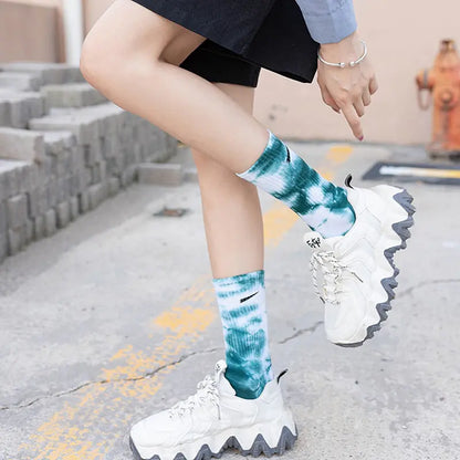 Luxurious Women's Tie-Dye Middle Tube Socks in vibrant teal, offering fashionable comfort for all-day style, paired with stylish chunky white sneakers.