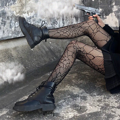 Women's Luxury Fishnet Design Tights styled with black combat boots, creating a bold fashion statement.