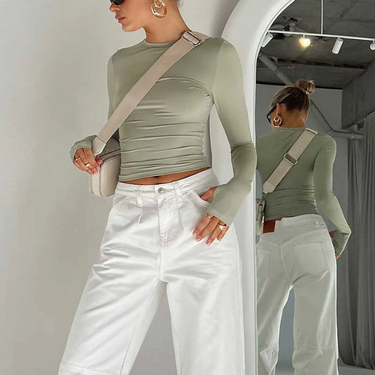 Streetwear Slim-Fit Long Sleeve Women's Fashion Designer Tee in olive green, complemented by a stylish crossbody bag and high-waisted white pants, reflecting contemporary fashion.