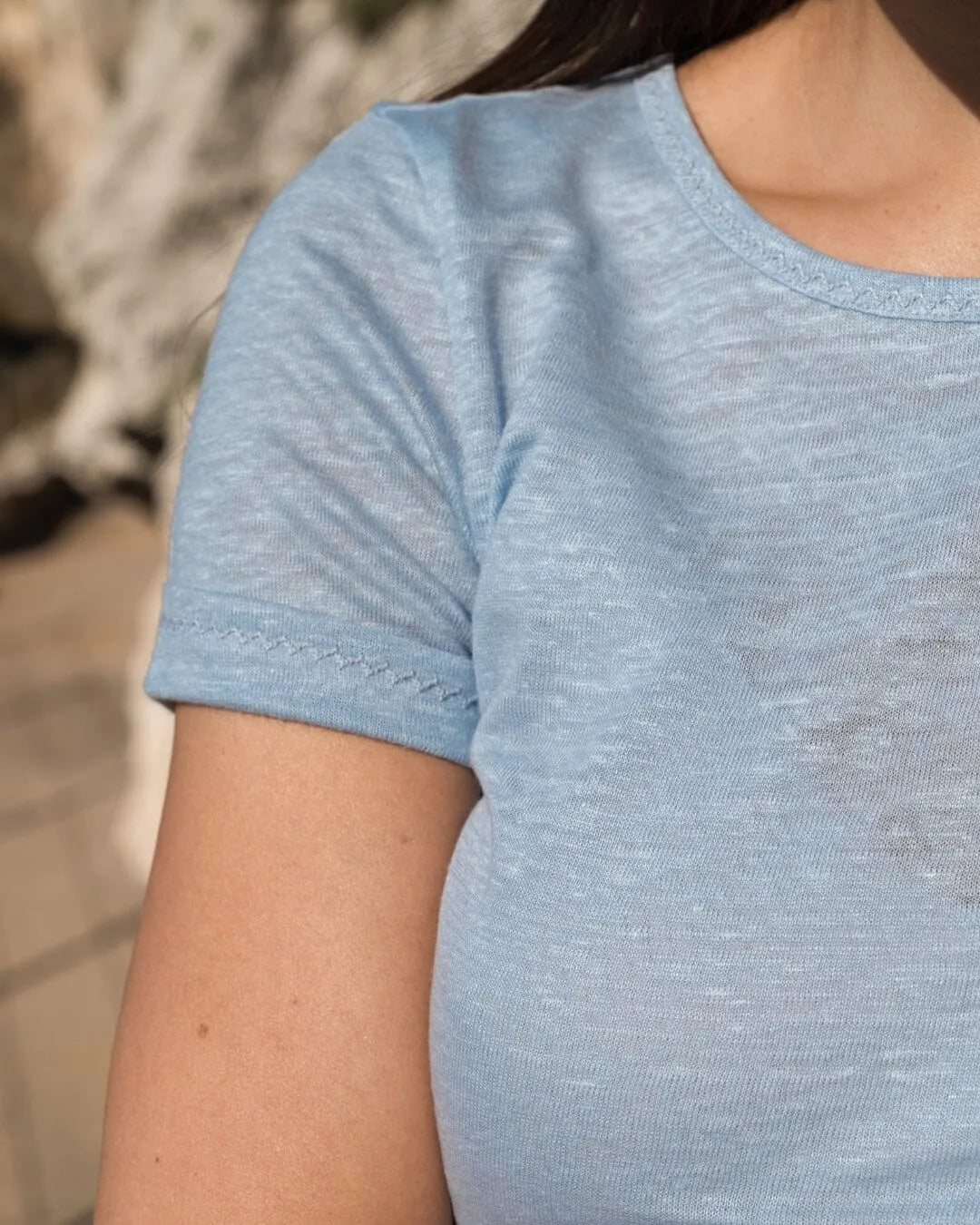 Versatile women's linen t-shirt paired with stylish denim shorts, perfect for a chic summer look.