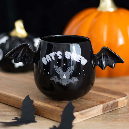 Charming display of the Gothic Bat Wing Mug amidst Halloween decorations, perfect for gothic aesthetic enthusiasts looking to elevate their spooky season experience.