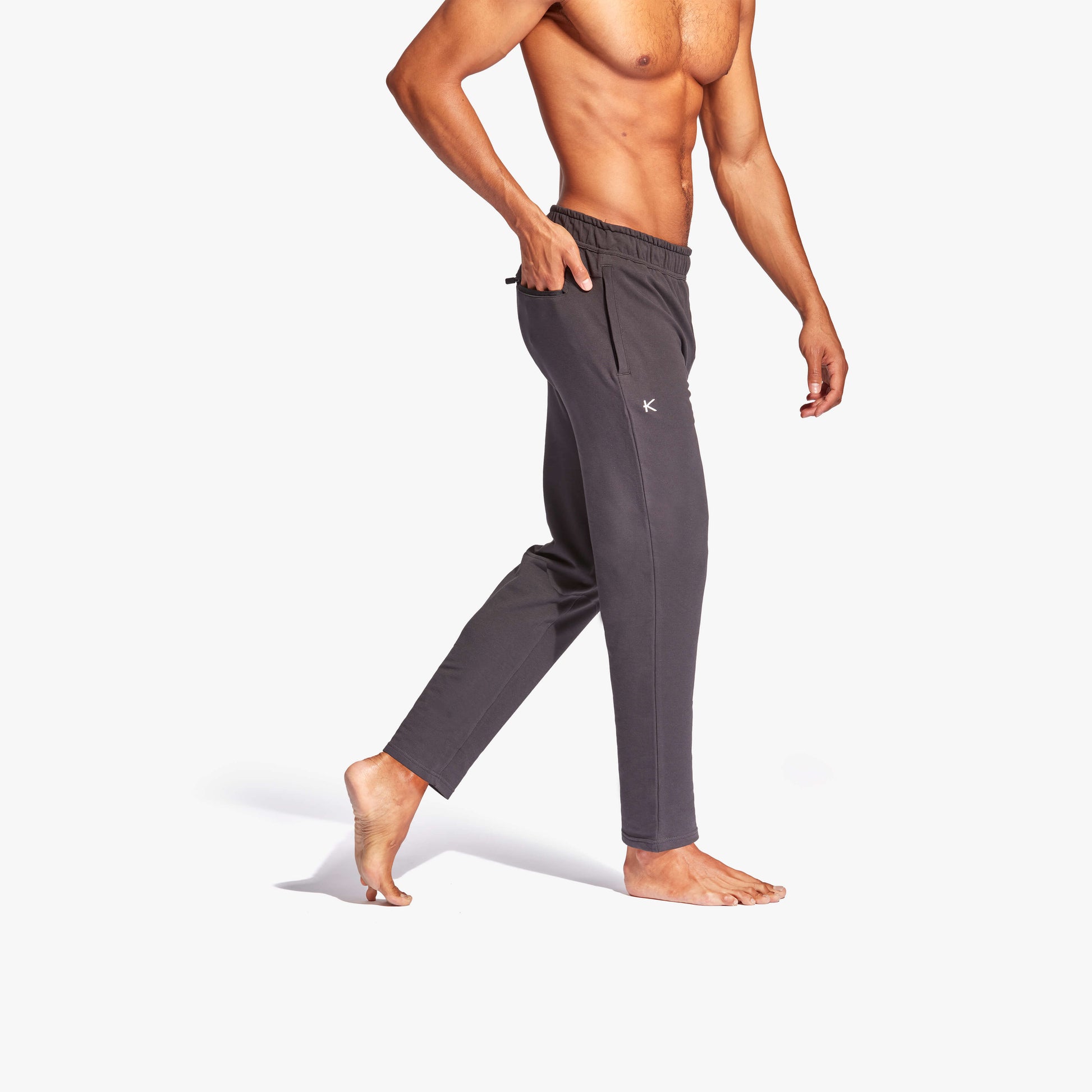 KYMIRA Men's Infrared Recovery Tracksuit Bottoms displayed in a modern gym setting, illustrating versatility for active wear or casual outings.