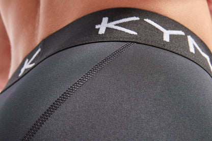 Model wearing KYMIRA Men's IR50 Infrared Recovery Leggings, demonstrating their fitted calves and stylish design for modern athletic wear.