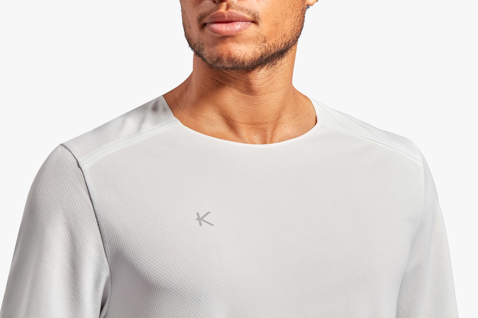 Men's KYMIRA Charge T-Shirt featuring durable fabric and an elongated back for superior fit and comfort during workouts.