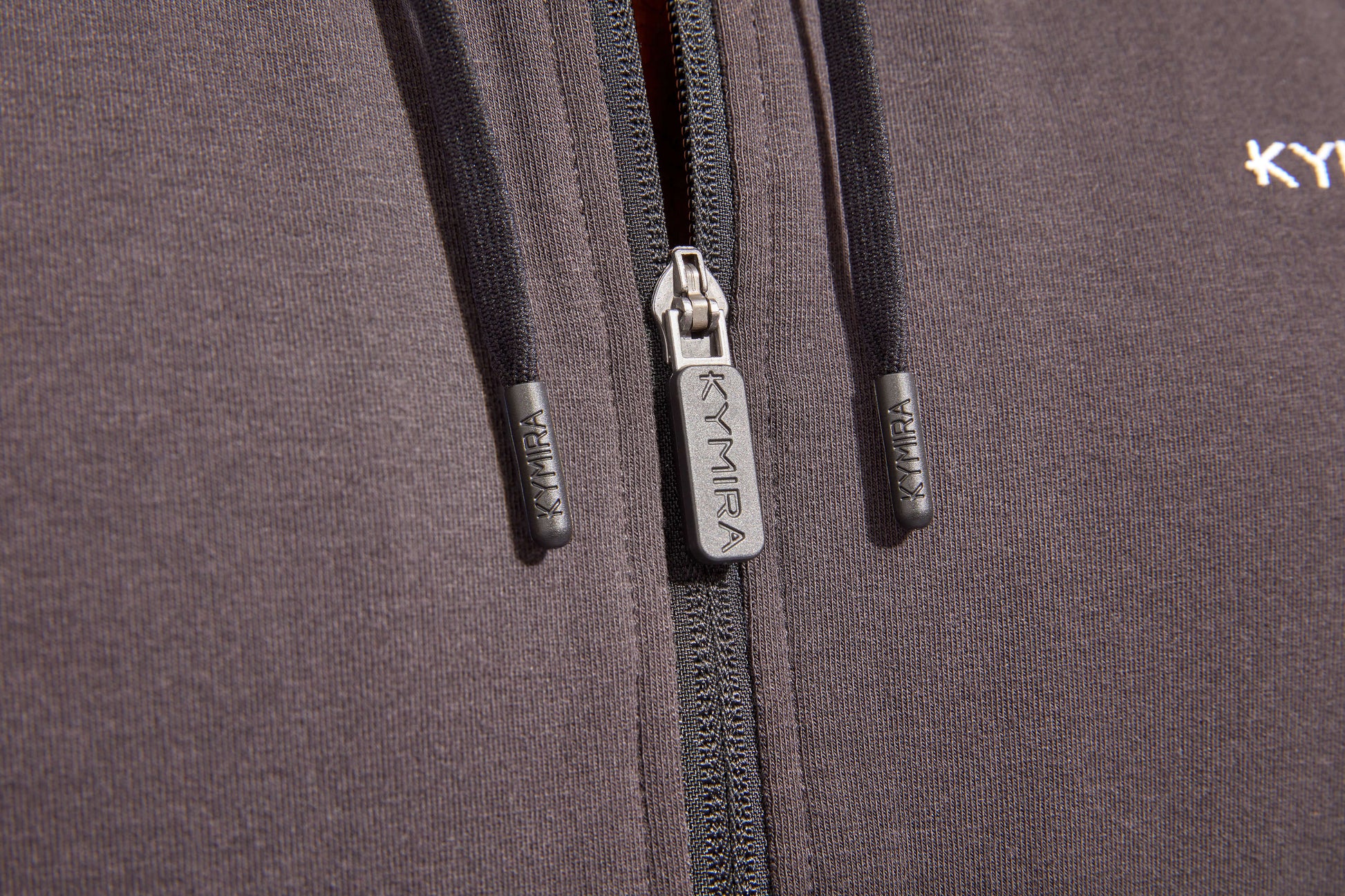 Elegant men's Celliant tracksuit top by KYMIRA in sophisticated style, perfect for athletic performance and casual outings, showcasing its full zip and modern drawstring hood for ultimate comfort.