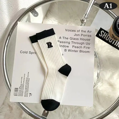 Luxurious Women's Tie-Dye Middle Tube Socks displayed elegantly on a stylish surface, showcasing a unique design with a classic black and white finish for vibrant comfort and all-day style.