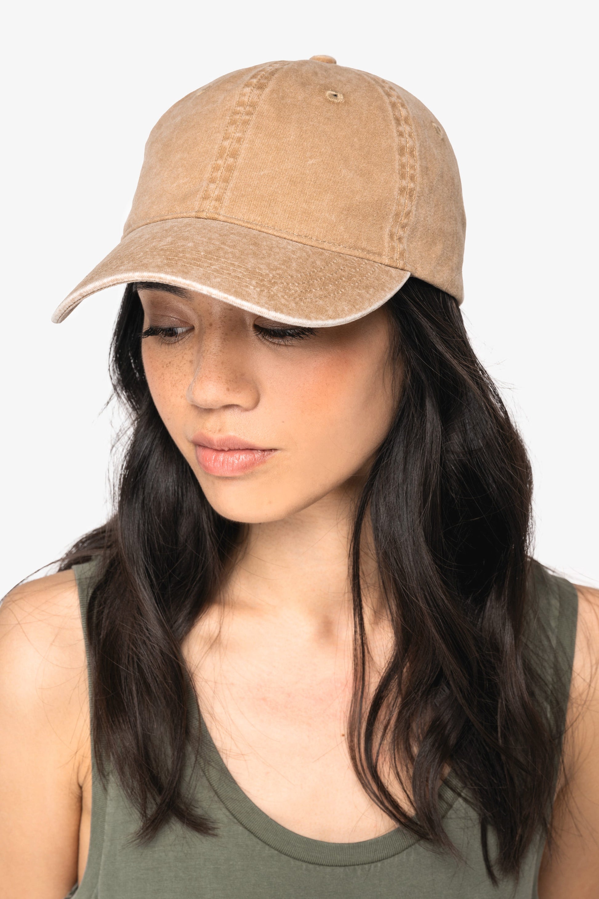 Model wearing luxury organic cotton faded cap outdoors, demonstrating its one-size-fits-most versatility.
