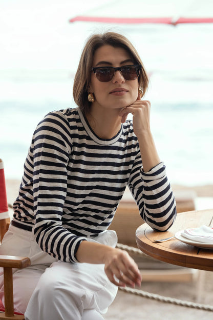 Lifestyle imagery of women wearing striped linen t-shirt, demonstrating relaxed fit and timeless elegance in vibrant outdoor setting.