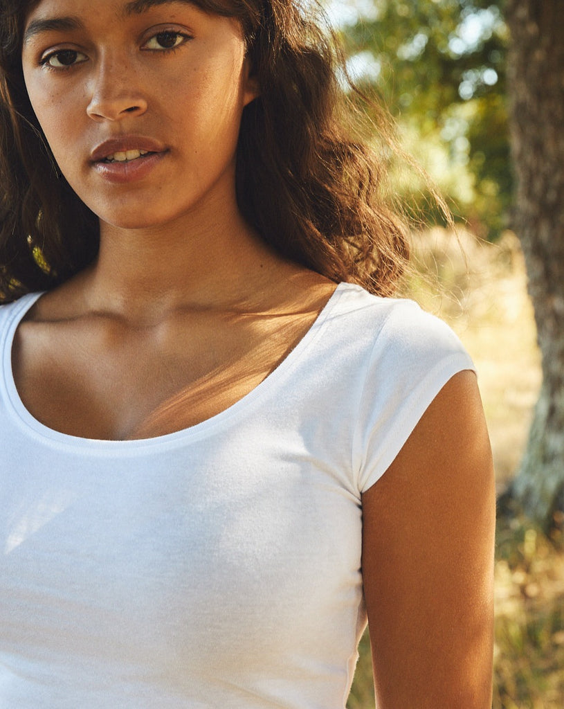 Stylish model wearing a luxury sustainable organic cotton slim-fit roundneck T-shirt, perfectly paired with jeans for a chic look.