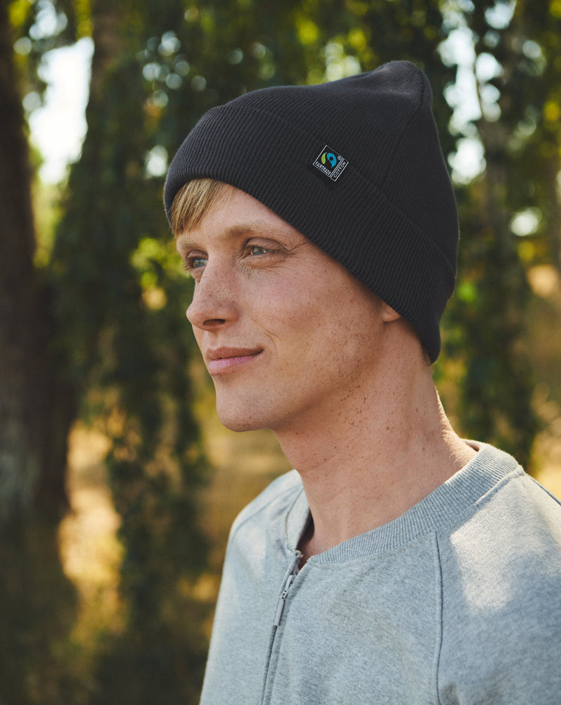 Stylish display of various colours of Fairtrade Organic Cotton Beanie, emphasizing its versatility as an ethical luxury accessory.
