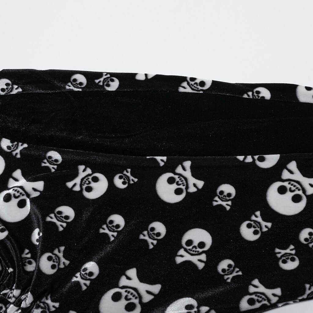 Fashionable display of Punk Rave flared trousers in black velvet with a unique skull design and waist tie, epitomising timeless gothic elegance.