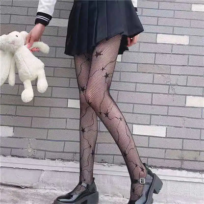 Chic black fishnet stockings with star pattern from Dazzling Dreams Studio, paired with a pleated skirt and holding a soft teddy bear, perfect for a trendy look.