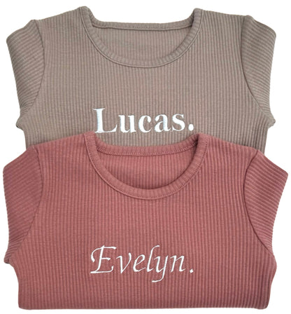 Family in matching DreamBuy luxury ribbed pyjamas set in leather pink, perfect for holiday play and sleep, embodying chic minimalist style for unforgettable family moments.