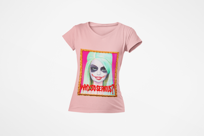 Luxurious pink women's graphic t-shirt featuring a pop art design of a playful Joker-inspired character with vibrant green hair and bold red lips, framed in gold.