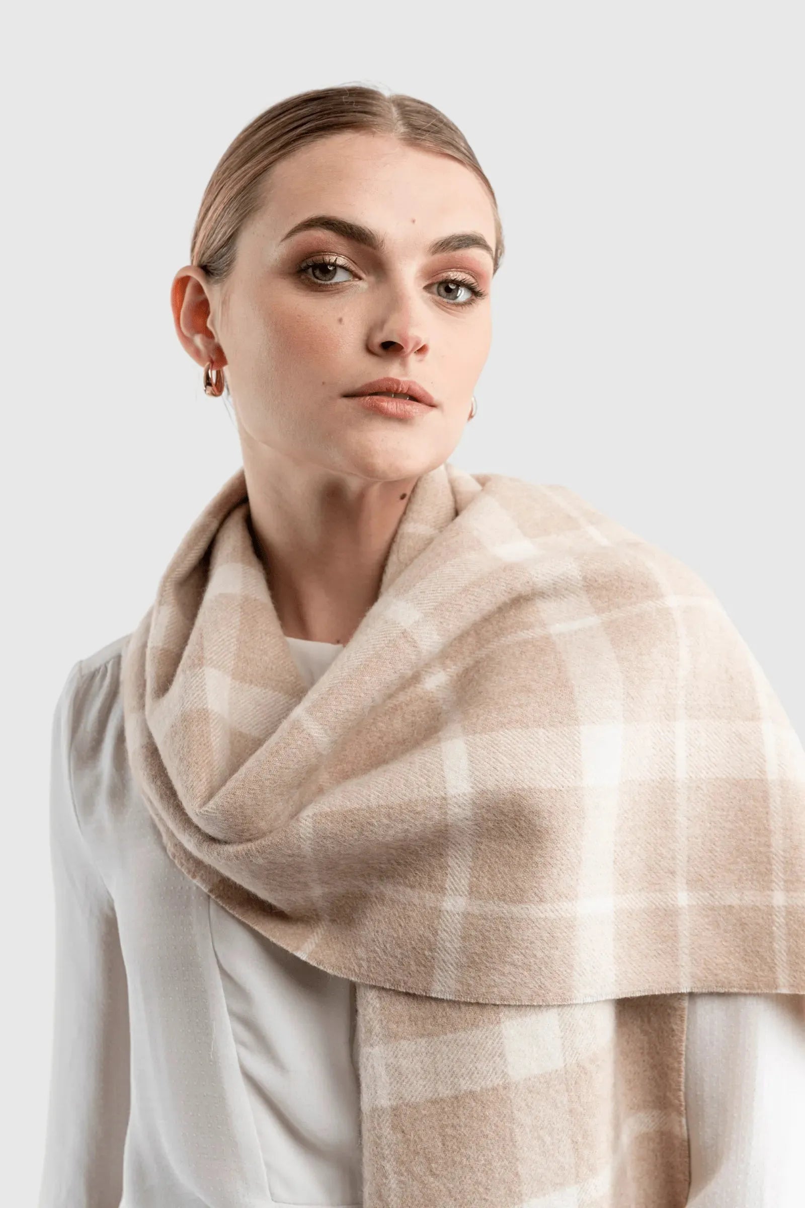 Elegant close-up of the undyed alpaca plaid scarf, highlighting the natural fibres' luxurious softness and rich texture.