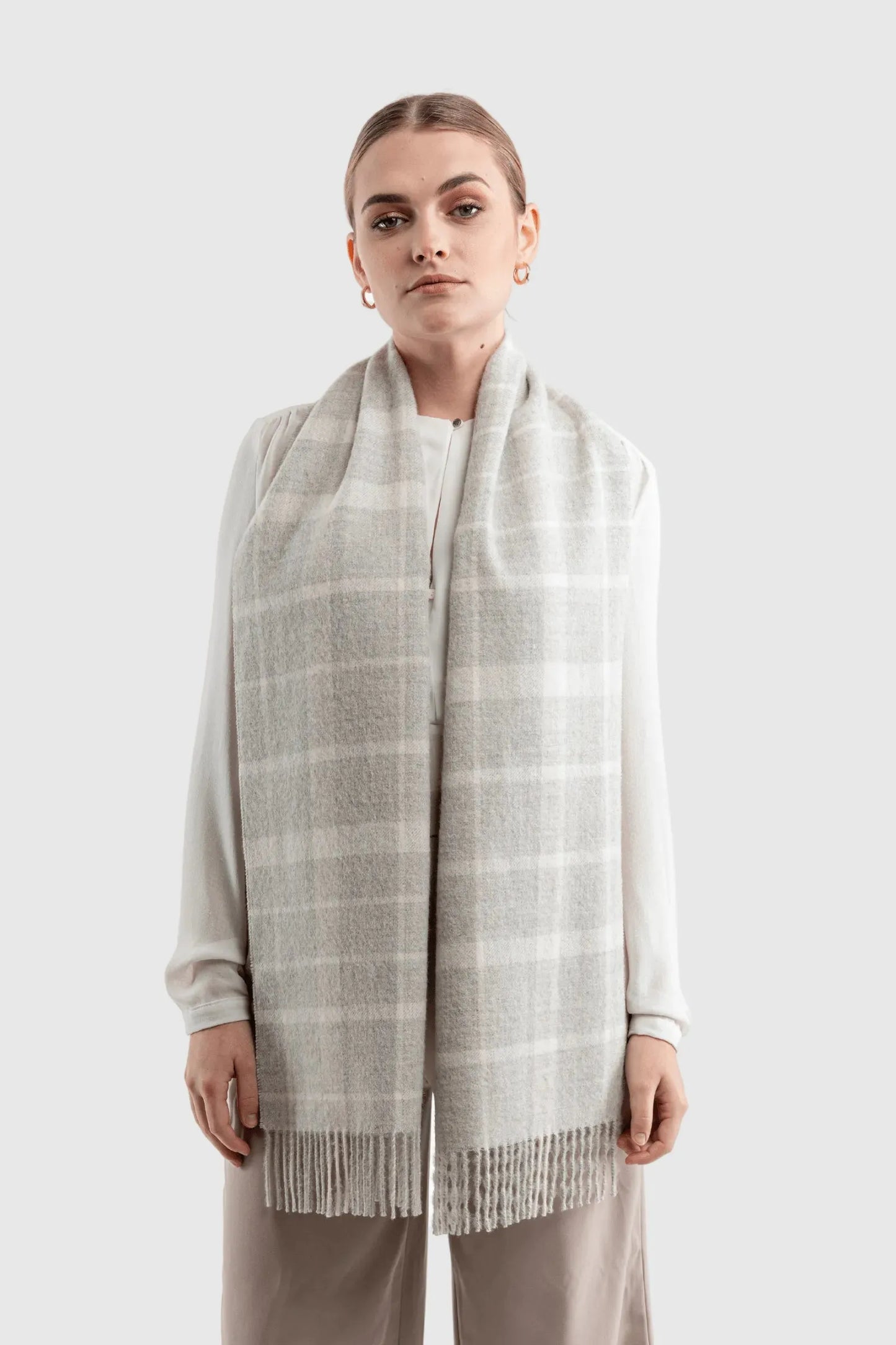 Chic styling of the Luxury Undyed Alpaca Plaid Scarf draped elegantly, featuring twisted fringes that add charm to any winter outfit.