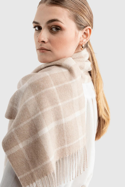 Fashion model wearing a luxury undyed alpaca plaid scarf, embodying sophisticated winter fashion with its warm and stylish design.