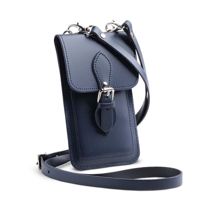 Luxury handmade navy blue leather mobile phone pouch by Zatchels, featuring a stylish magnetic fastener and adjustable crossbody strap, ideal for carrying smartphones elegantly.