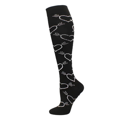 Elegant Women's Knee Length Compression Travel Socks adorned with a whimsical heart pattern on a black background, perfect for fashionable travel and leg support.