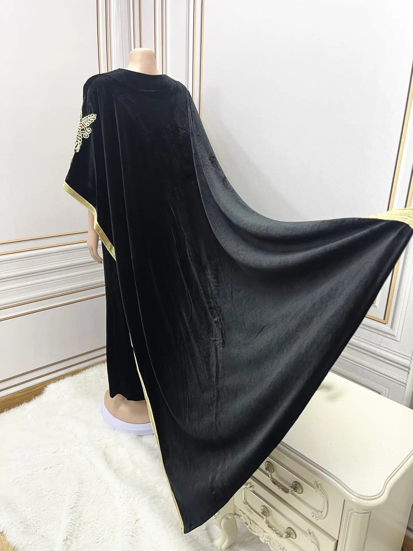 A model wearing a stylish golden velvet abaya with bat sleeves, ideal for sophisticated Ramadan celebrations and Muslim occasions.