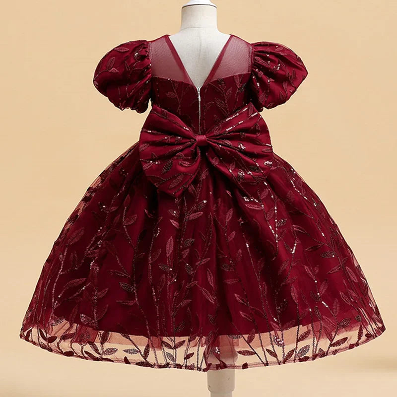 Charming short-sleeved dress for girls, adorned with intricate bow decoration, designed for festive occasions and memorable moments.