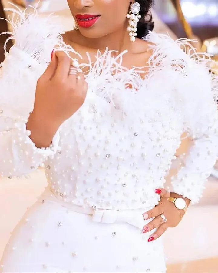 Elegant long sleeve white dress displayed on a model, highlighting the flattering fit and traditional African design elements for women.