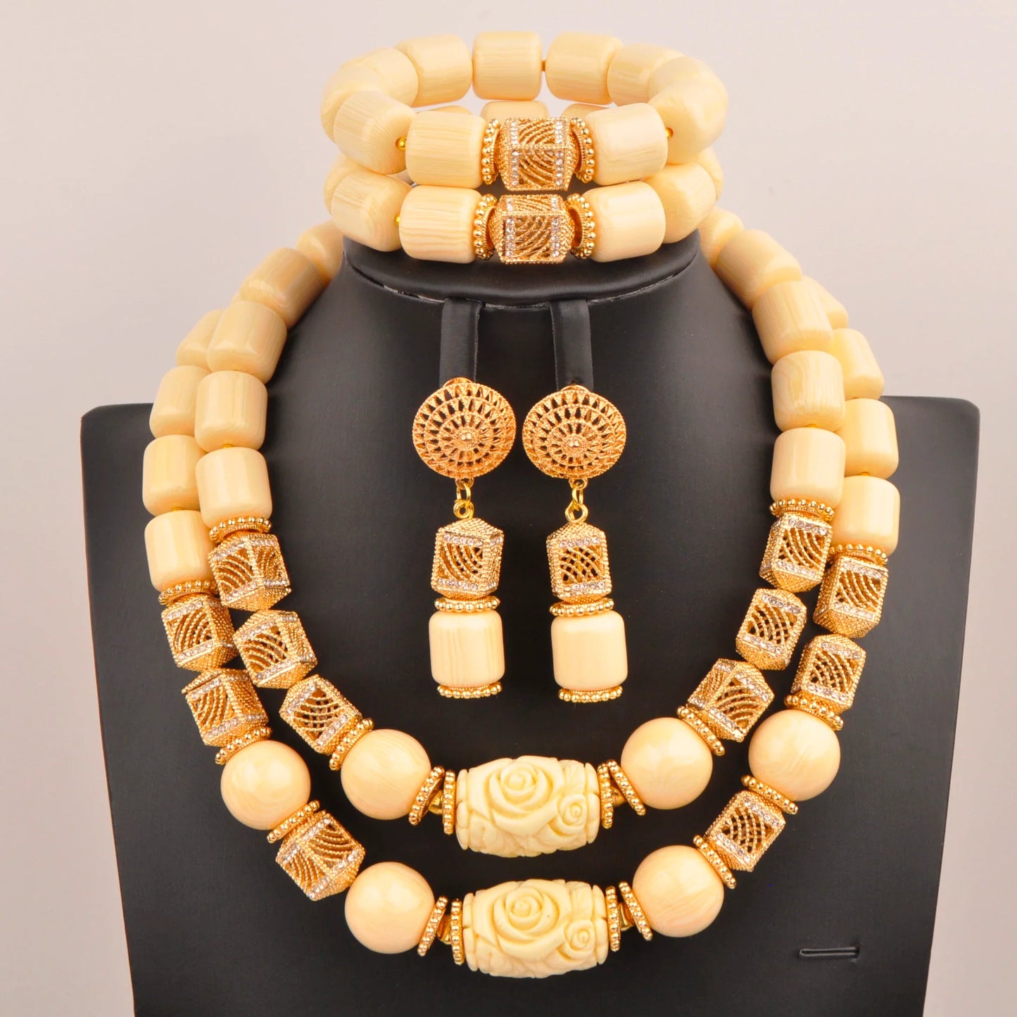 Nigerian bridal jewelry set displayed elegantly on a soft fabric background, comprised of a beautiful necklace, bracelet, and earrings, renowned for their romantic design.