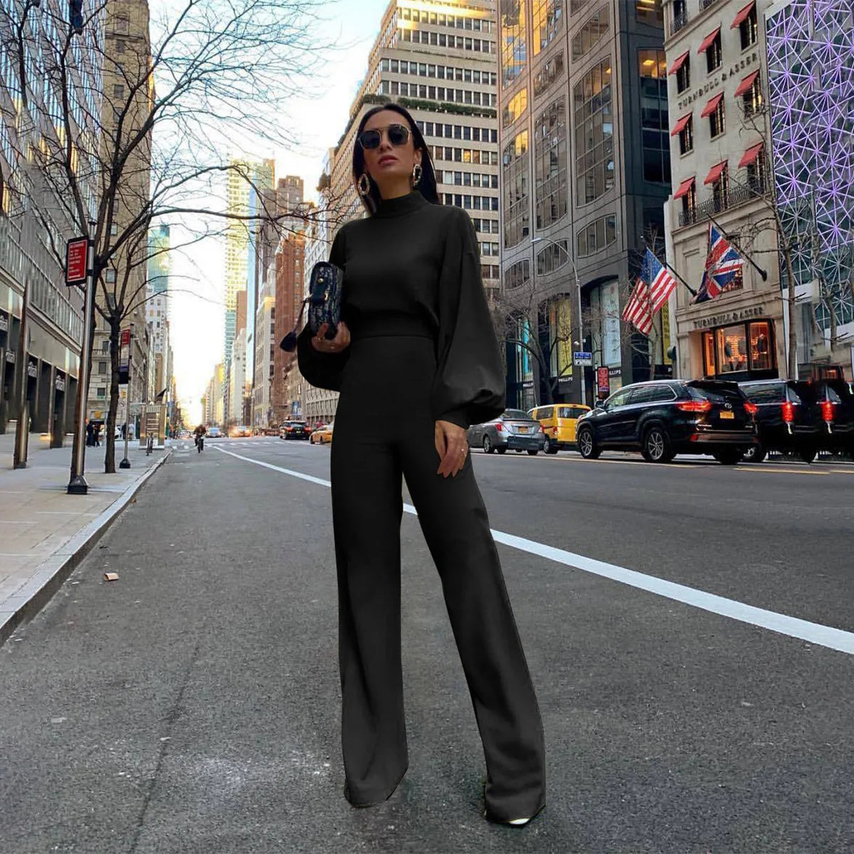 Full-length view of a sophisticated black jumpsuit, emphasizing its luxurious fabric and contemporary design ideal for stylish autumn/winter outings.